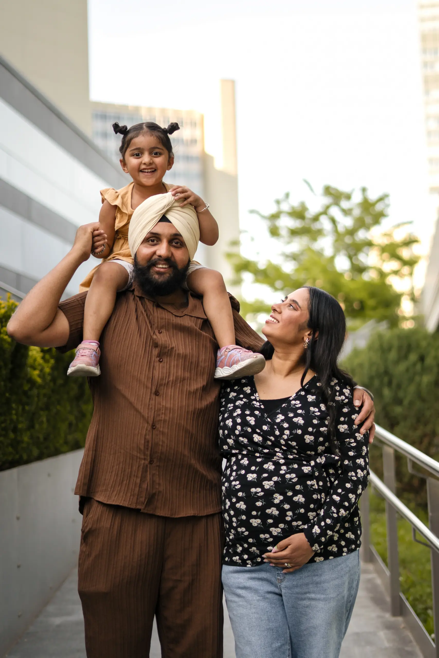 Eine indische Familie mit Kleinkind bei unserem Babybauchshooting. Der Papa trägt das Kleinkind auf den Schultern.